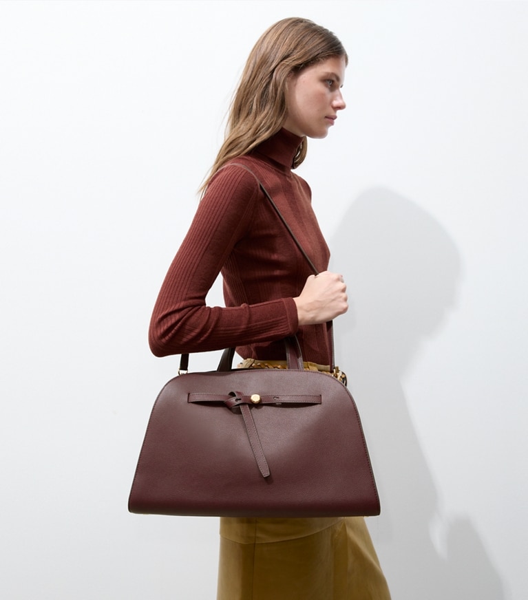 Tory Burch designer satchels Romy Bauletto in Dark Carmine additional on model