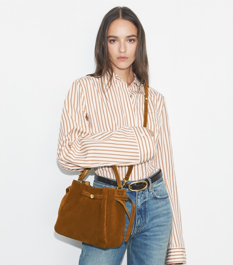 Tory Burch designer crossbody bags Romy Bucket Bag aus Wildleder in Park Bench accessory on model