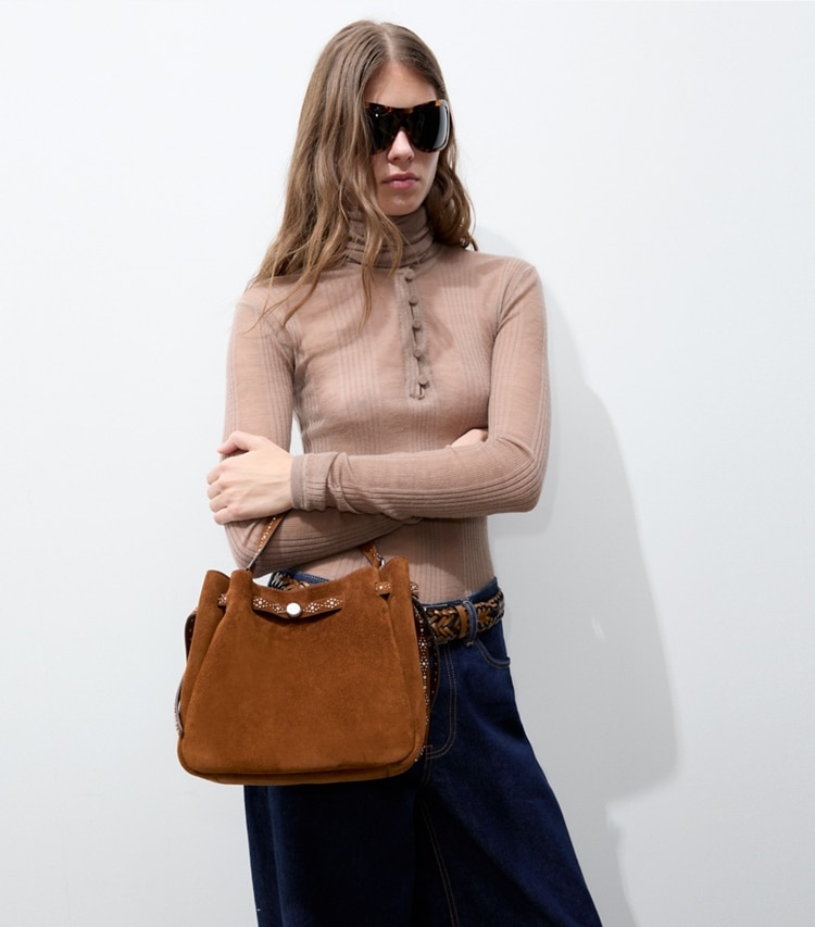 Tory Burch designer crossbody bags Romy Studded Suede Bucket Bag in Caramel accessory on model