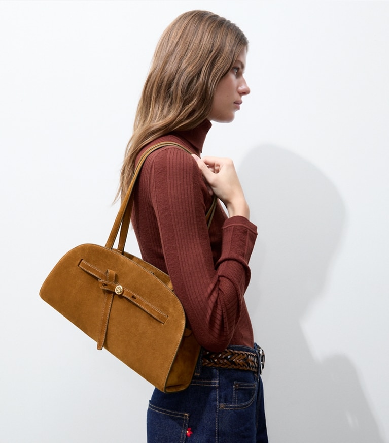 Tory Burch designer shoulder bags Romy Suede East-West Bauletto in Caramel accessory on model