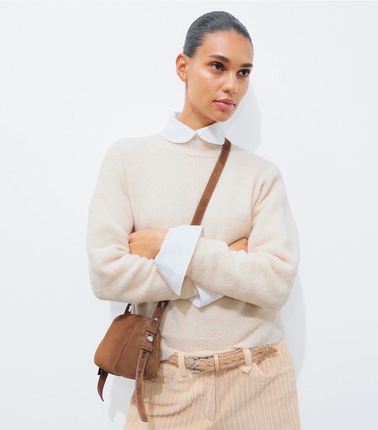 Tory Burch designer crossbody bags Romy Suede Soft Crossbody Bag in Caramel accessory on model