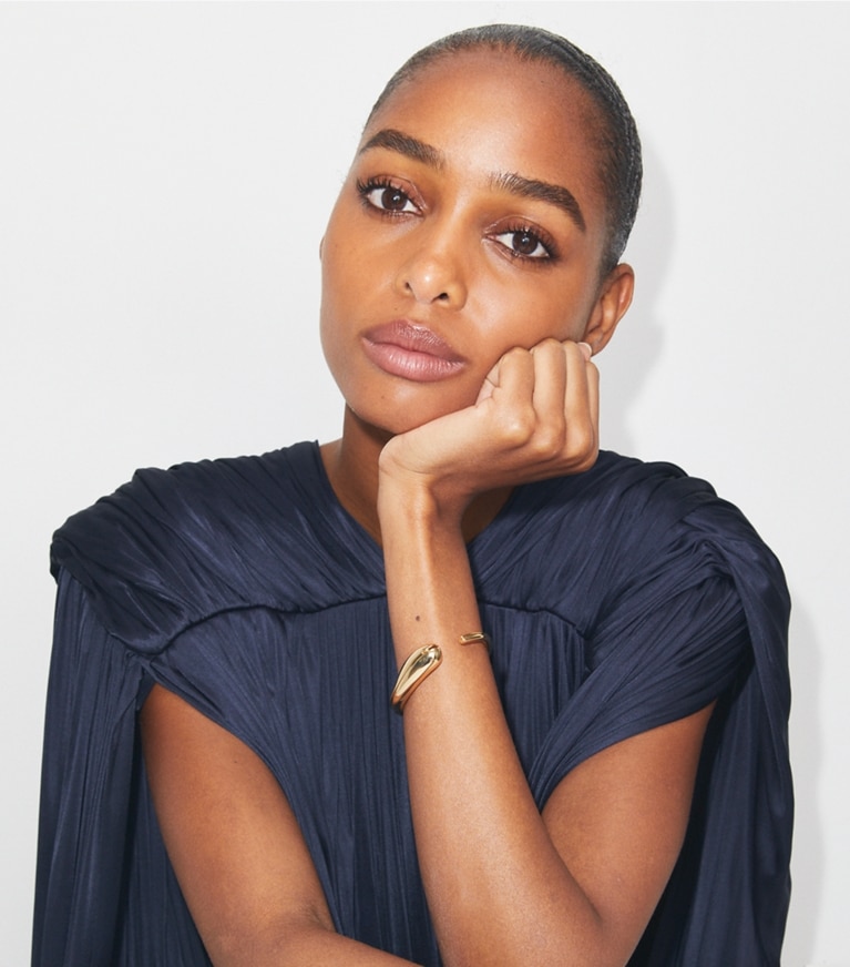 Tory Burch designer armbänder Schmale Armspange mit Piercingdetail in Light Brass front