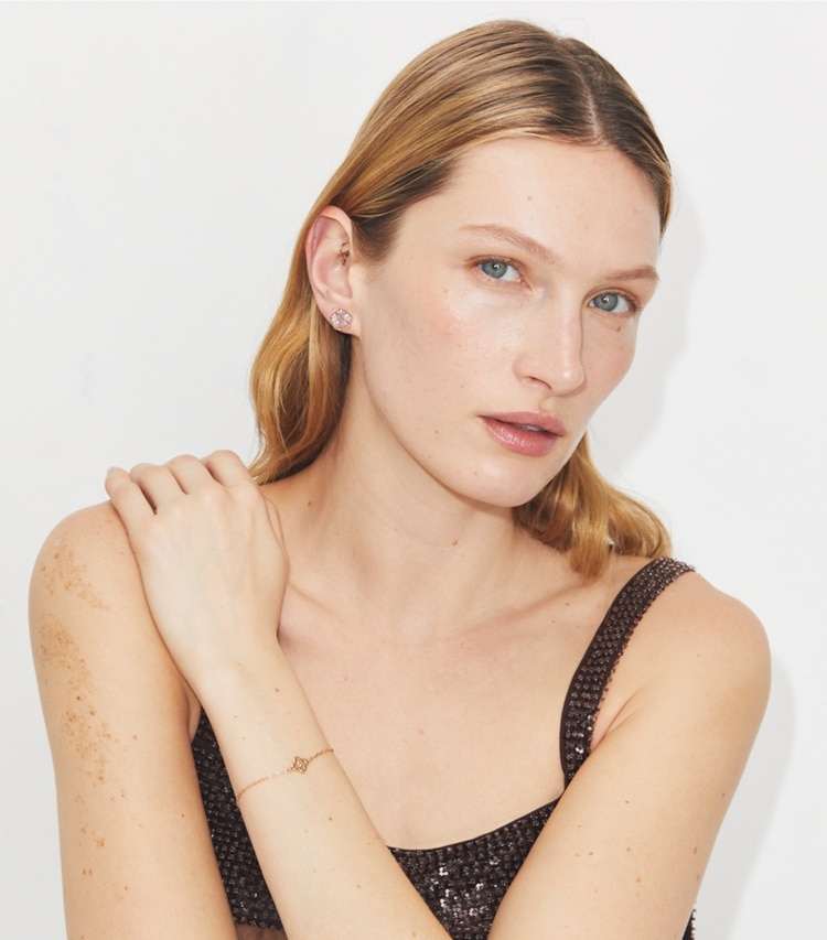 Tory Burch designer イヤリング＆ピアス フォーゲットミーノット スモール スタッズピアス in Tory Gold / Mother of Pearl accessory on model