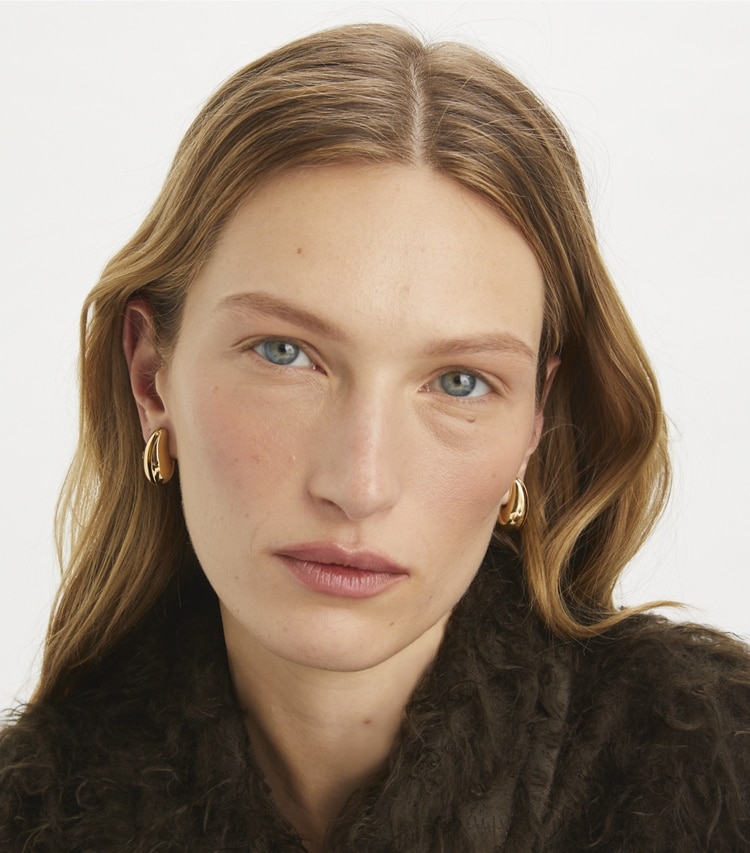 Tory Burch designer earrings Small Pierced Earrings in Light Brass accessory on model