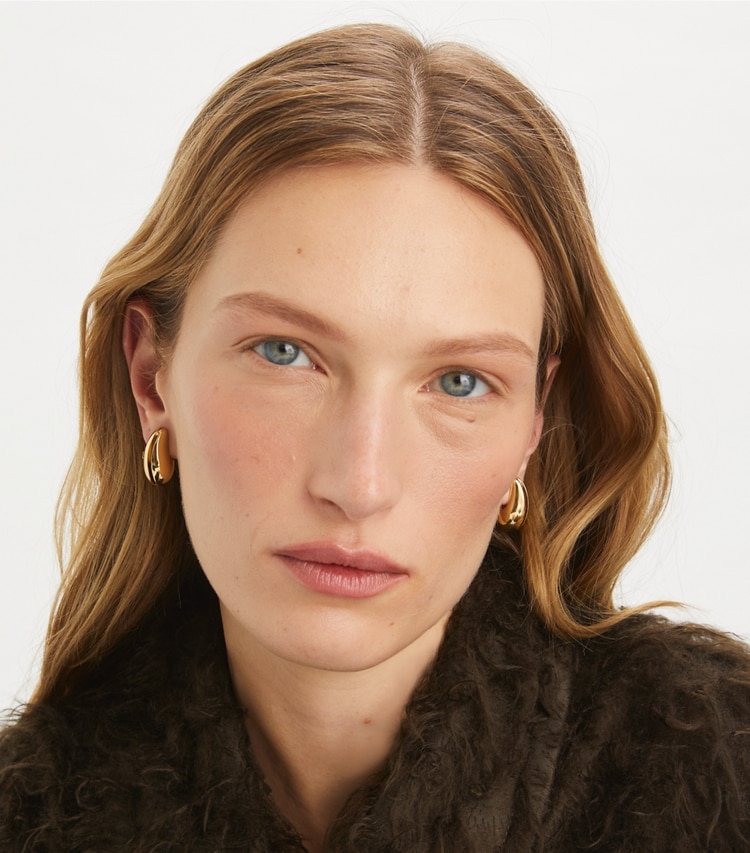 Tory Burch designer earrings Small Wave Earring in Light Brass accessory on model