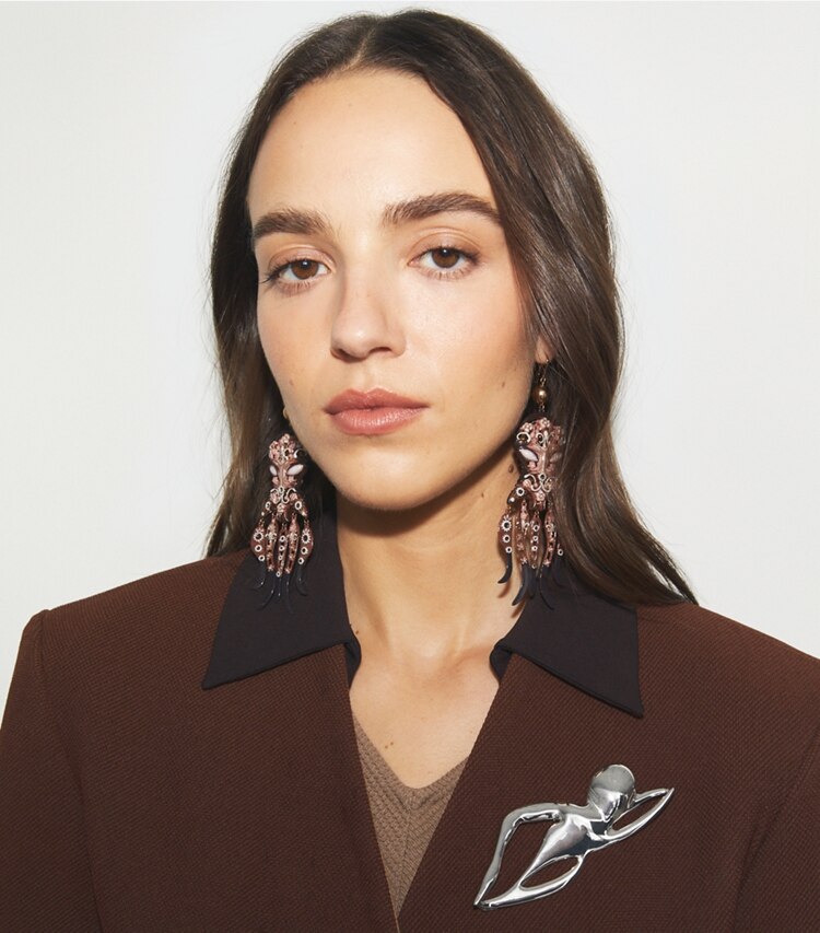 Tory Burch designer forcina Spilla con nuotatore in Light Silver accessory on model