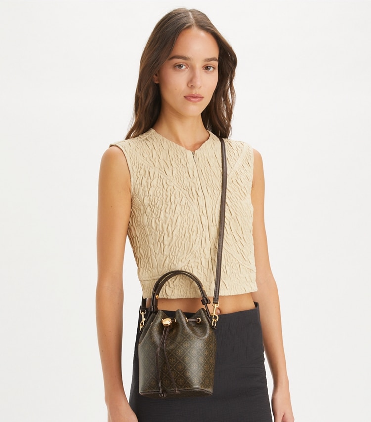 Tory Burch designer crossbody bags T Monogram Coated Canvas Mini Bucket Bag in French Press accessory on model