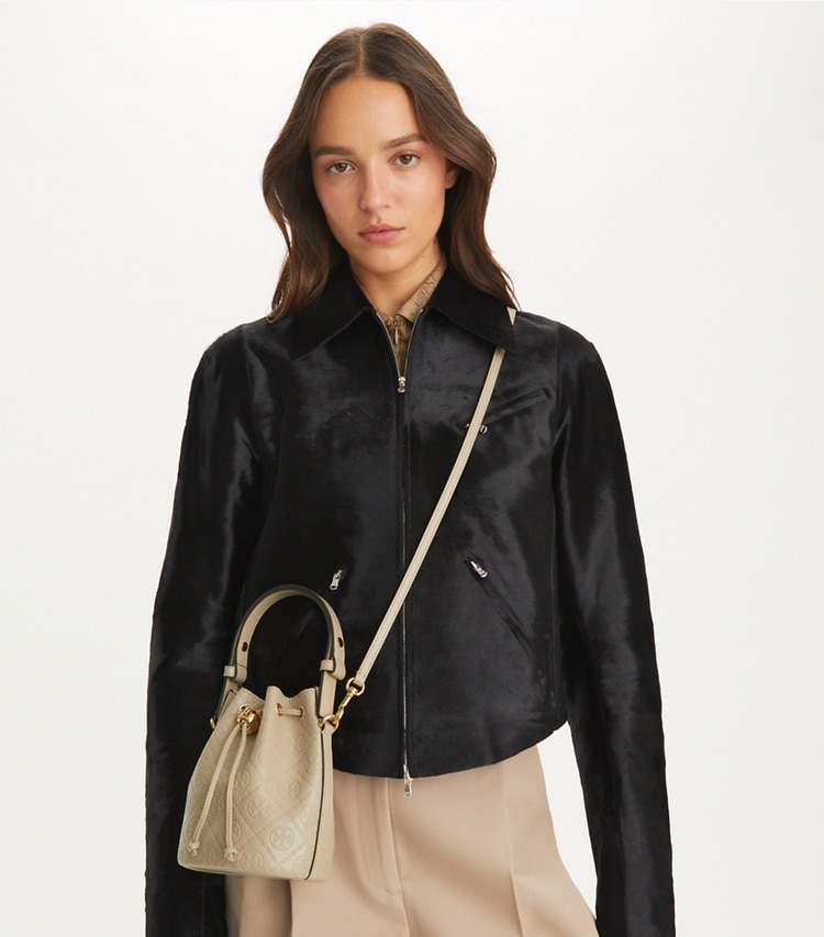 Tory Burch designer crossbody bags T Monogram Leather Mini Bucket Bag in Fresh Clay accessory on model