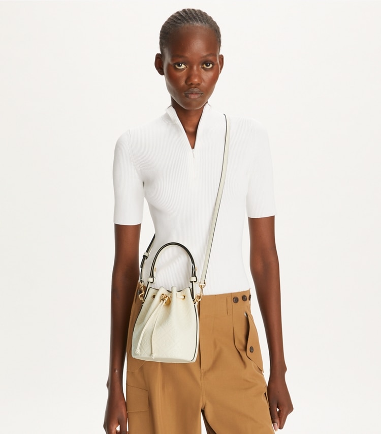 Tory Burch designer クロスボディバッグ Tモノグラム レザー ミニ バケットバッグ in Light Cream accessory on model