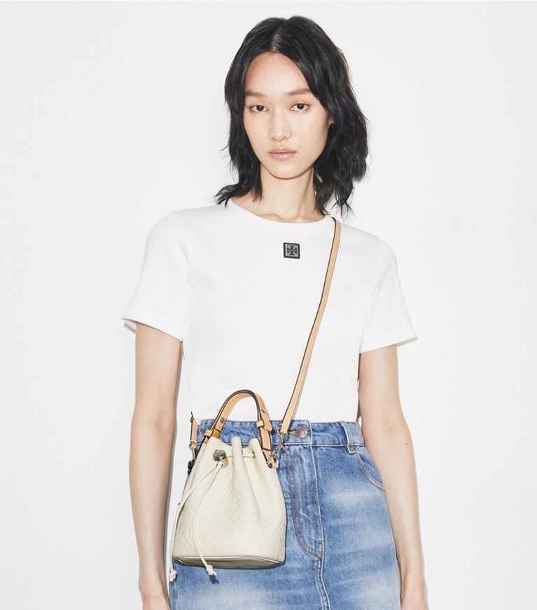 Tory Burch designer クロスボディバッグ Tモノグラム ペブル バケットバッグ in Warm White accessory on model