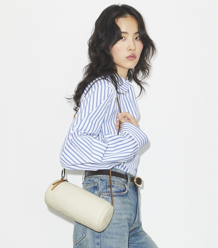 Tory Burch designer クロスボディバッグ Tモノグラム ペブルド シリンダーバッグ in Warm White accessory on model