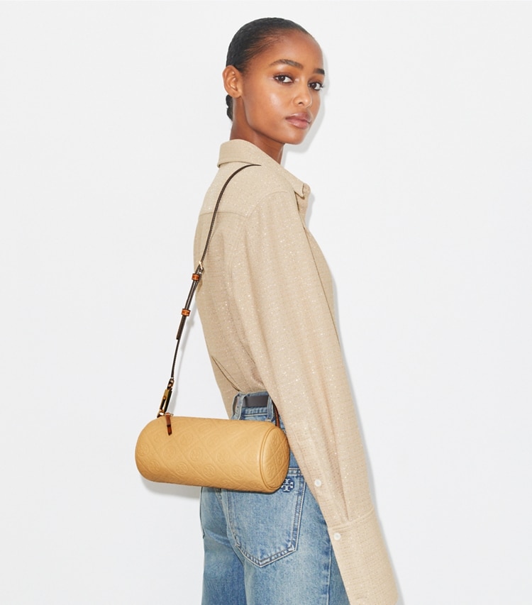 Tory Burch designer crossbody bags T Monogram Pebbled Cylinder Bag in Biscotti accessory on model