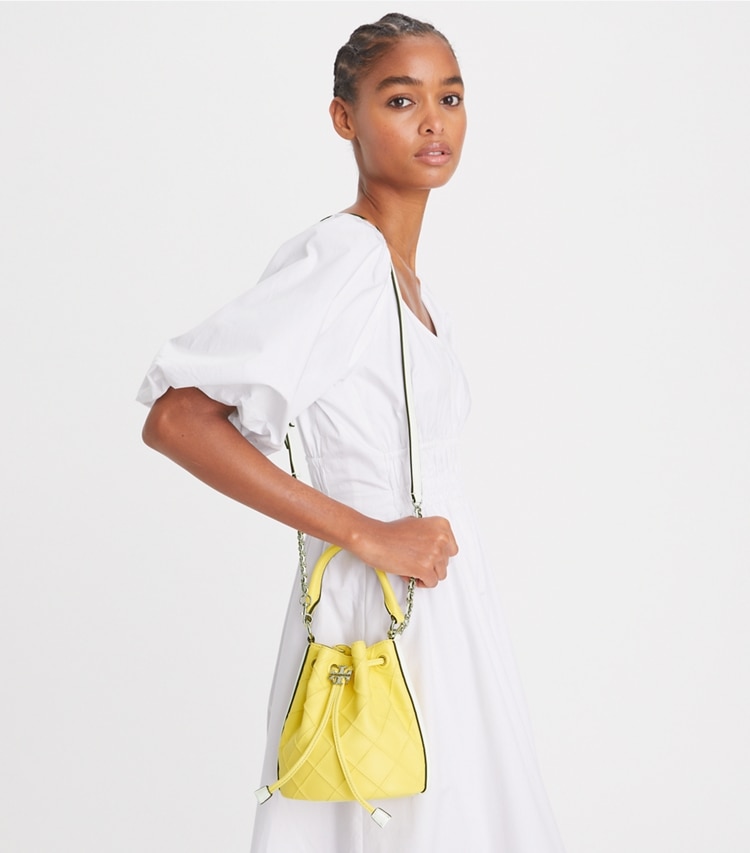 Tory Burch designer crossbody bags Weiche Mini Fleming Beuteltasche mit Lackrand in Vintage Lemon / Optic White accessory on model