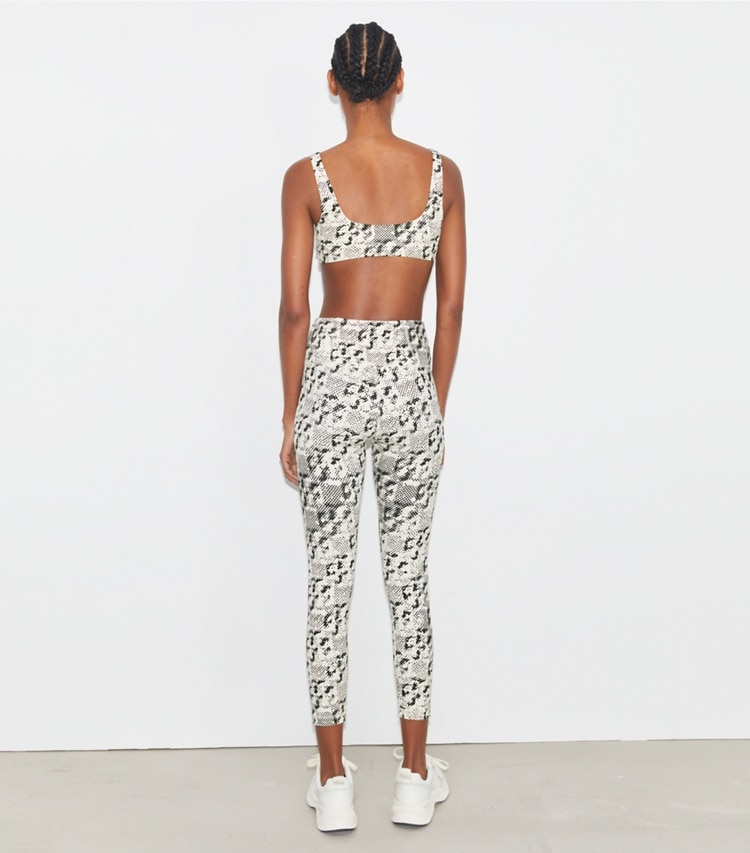 Tory Sport designer bottoms Weightless Printed 7/8 Legging in New Ivory Distressed Pixelated Logo on model back