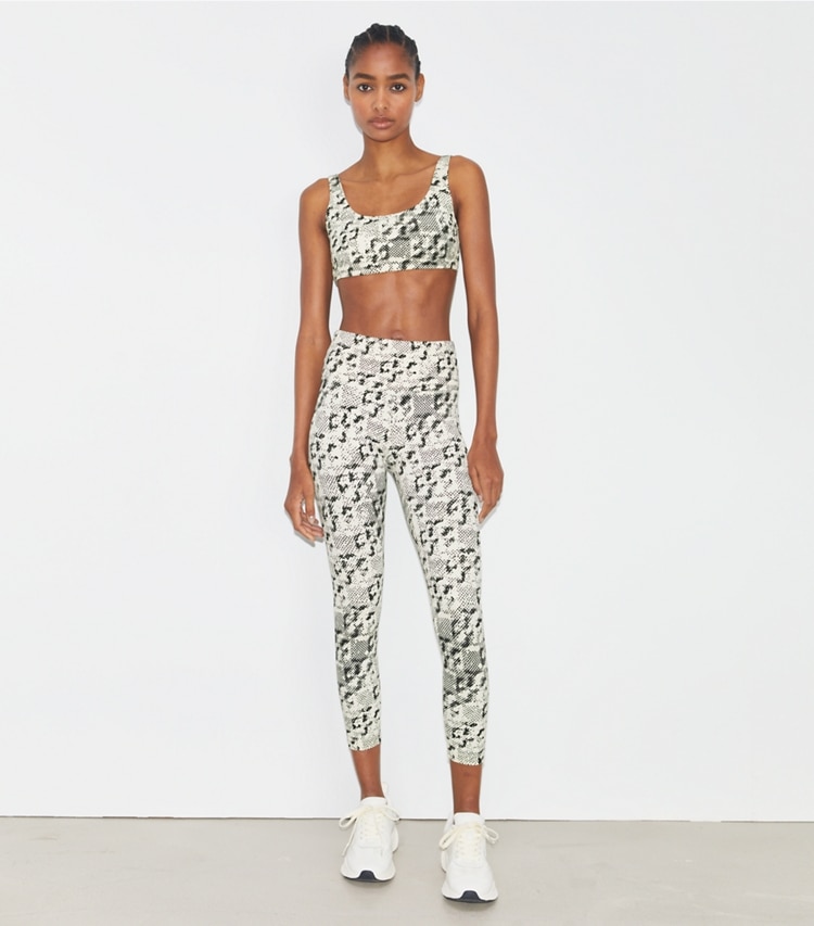 Tory Sport designer bottoms Weightless Printed 7/8 Legging in New Ivory Distressed Pixelated Logo on model front